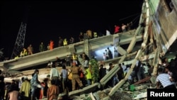 Bangladeshi Army personnel and civilian volunteers work at the scene of a collapsed building near Dhaka. 