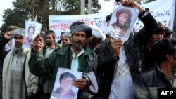 Afghan men in Herat shout anti-Iran slogans as they display pictures of their family members who have allegedly been killed by Iranian forces on December 9.