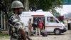 A member of India's security forces stands guard as police search a van on the Jammu-Srinagar highway at Nagrota on August 2.