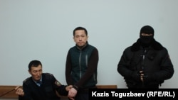 Гражданский активист Асет Абишев (в центре), принудительно доставленный из следственной тюрьмы в Алмалинский районный суд для присутствия на оглашении приговора. Алматы, 30 ноября 2018 года. 