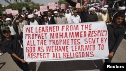 Iraqis hold a banner and shout slogans during a protest against a film seen as insulting the Prophet Muhammad in Basra.