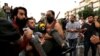 Demonstrators carry a man affected by tear gas during a protest in Baghdad on October 25.