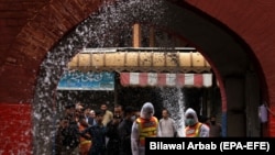 Pakistani workers spray disinfectants on a road in Peshawar, the provincial capital of Khyber Pakhtunkhwa, after authorities closed them to fight against the spread of the coronavirus on March 23.