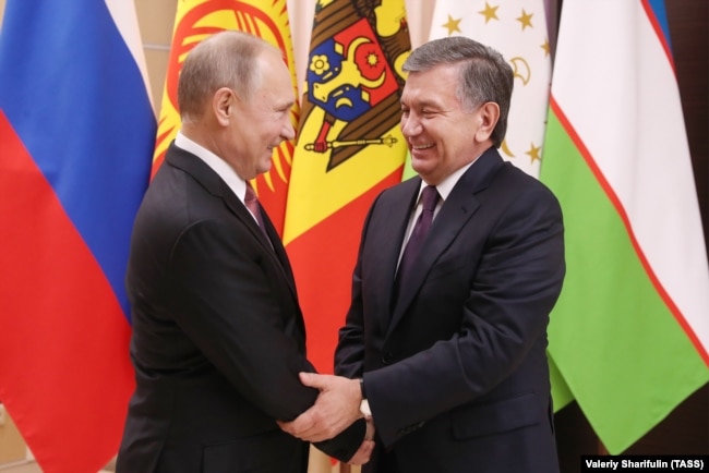Mirziyoev met with Russian President Vladimir Putin (left) outside Moscow on December 26.