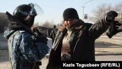 Полицей ер адамды тексеріп тұр. Жаңаөзен, 19 желтоқсан 2011 жыл. (Көрнекі сурет)