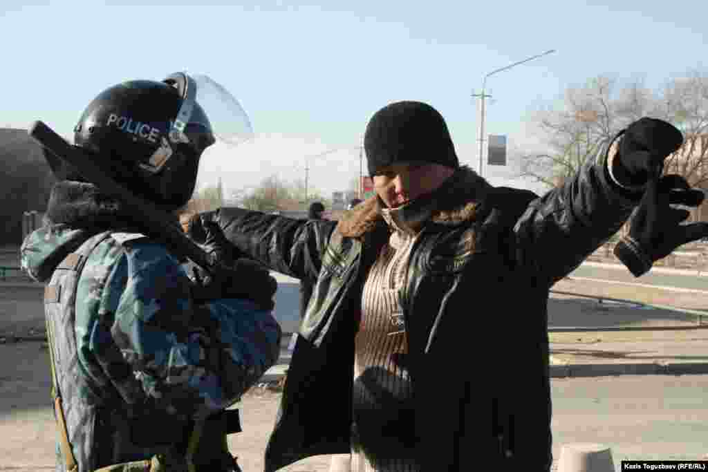 Полиция қызметкері жергілікті тұрғынды тексеріп тұр. Жаңаөзен, 19 желтоқсан 2011 жыл