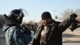 Полицей қала тұрғынын тексеріп тұр. Жаңаөзен, 19 желтоқсан 2011 жыл.