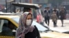 Iranians wear masks to help guard against dangerous levels of air pollution as they walk in the center of the smog-filled capital Tehran, November 13, 2019