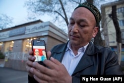Omirbek Bikalaj prikazuje fotografiju svojih roditelja za koje vjeruje da su zatočeni u Kini.