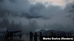 Migrants stand in fog inside Vucjak camp near Bihac
