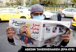 A man reads a copy of the Iranian daily Sobhe Nou in Tehran on November 7 that features a cartoon depicting U.S. President Donald Trump and a headline reading: "Go To Hell, Gambler."