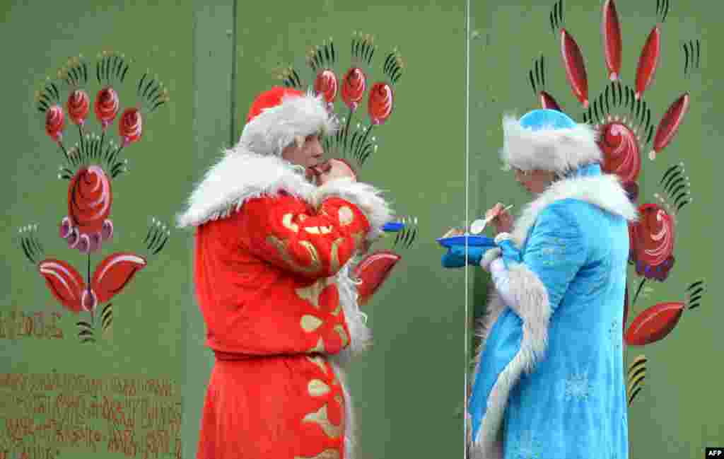 مرد و زنی که لباس &laquo;بابا سرما&raquo; پوشیده اند، در مراسم کریسمس مسیحیان ارتدوکس در کی یف، پایتخت اوکراین
