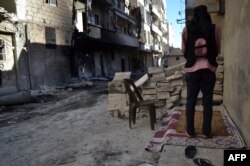 Боец вооруженной сирийской оппозиции молится на улице в Алеппо. 14 сентября 2013 года