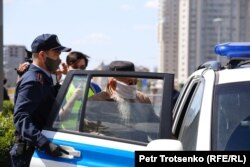 Полиция Тәуелсіздік алаңы маңынан ұстаған адамды көлікке салып әкеткелі жатыр. Нұр-Сұлтан, 6 маусым 2020 жыл.