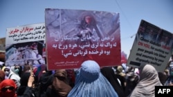 Afghan women hold up placards of Farkhunda Malikzada during a protest in Kabul in July 2015.