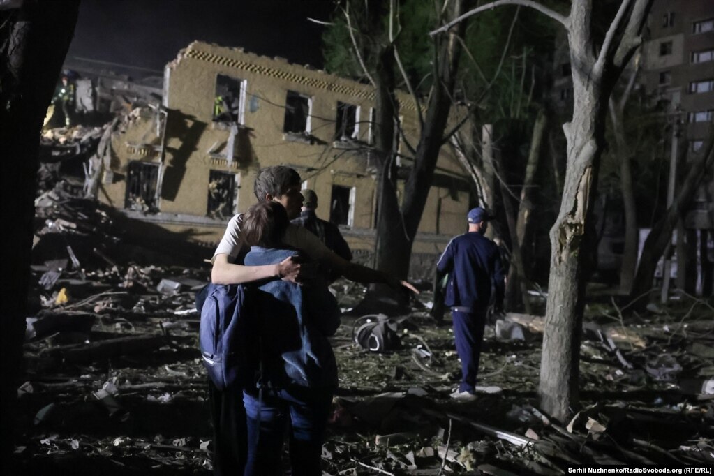 Люди дивляться на наслідки обстрілу