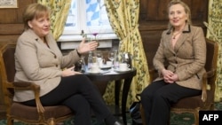 U.S. Secretary of State Hillary Clinton (right) and German Chancellor Angela Merkel confer before a meeting at the Munich Security Conference on February 5.