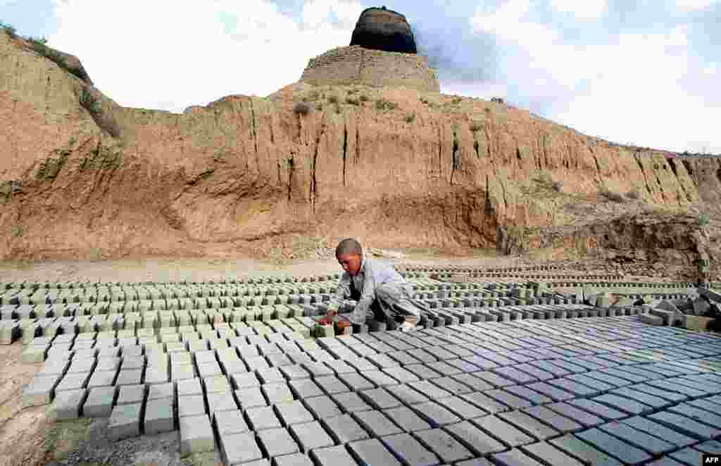 Ten-year-old Afghan boy Ismaeel works at a brick factory on the outskirts of Kabul in 2002, when Afghan and international officials were facing the brutal reality of rebuilding a country already devastated by decades of war.