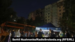 Люди біля пошкодженого будинка у Голосіївському районі Києва, 3 вересня 2026 року