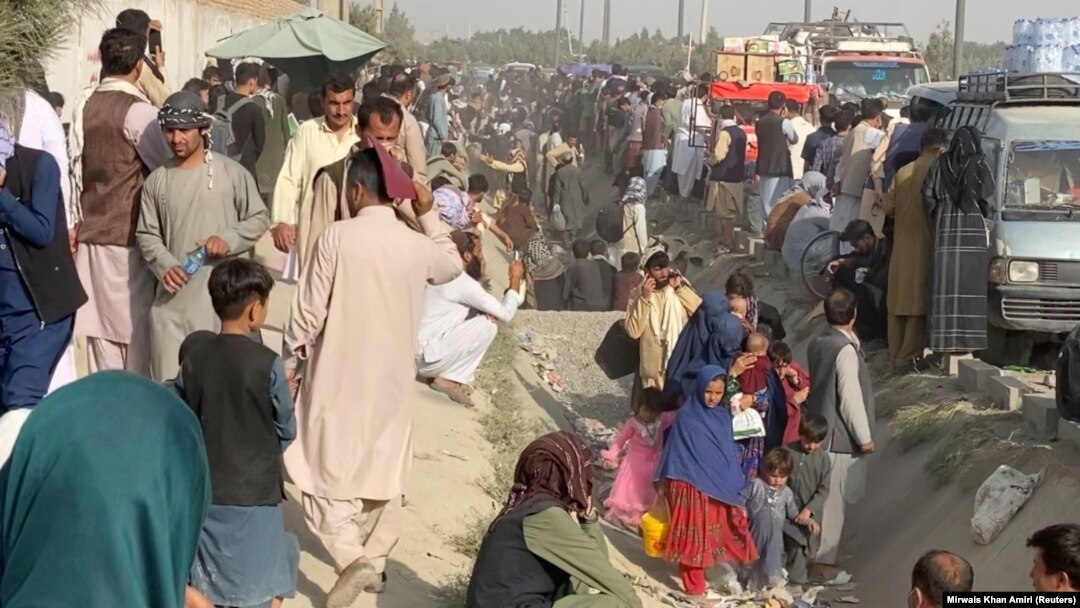 People wait outside the airport in Kabul on August 19.