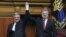 Ukrainian President Petro Poroshenko (right) raises aloft the hand of his Polish counterpart Bronislaw Komorowski during a session of the parliament in Kyiv on April 9. 