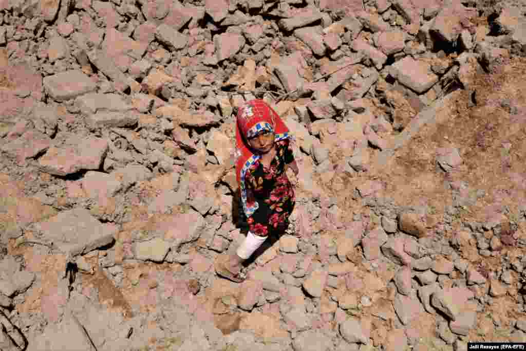 A girl walks amid the debris of a house that was destroyed in flash floods in a village in Herat Province, Afghanistan. At least 46 people died and another 15 remain missing after heavy rains and flash floods hit 15 of the country&#39;s 34 provinces. (epa-EFE/Jalil Rezayee)