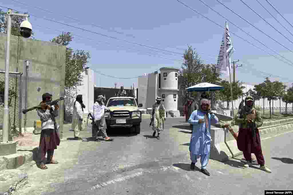 Taliban fighters stand guard at an entrance gate outside the Interior Ministry in Kabul.