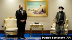 U.S. Secretary of State Mike Pompeo (left) meets with Mullah Abdul Ghani Baradar, head of the Taliban's peace negotiation team, amid talks between the Taliban and the Afghan government, in Doha on November 21, 2020.