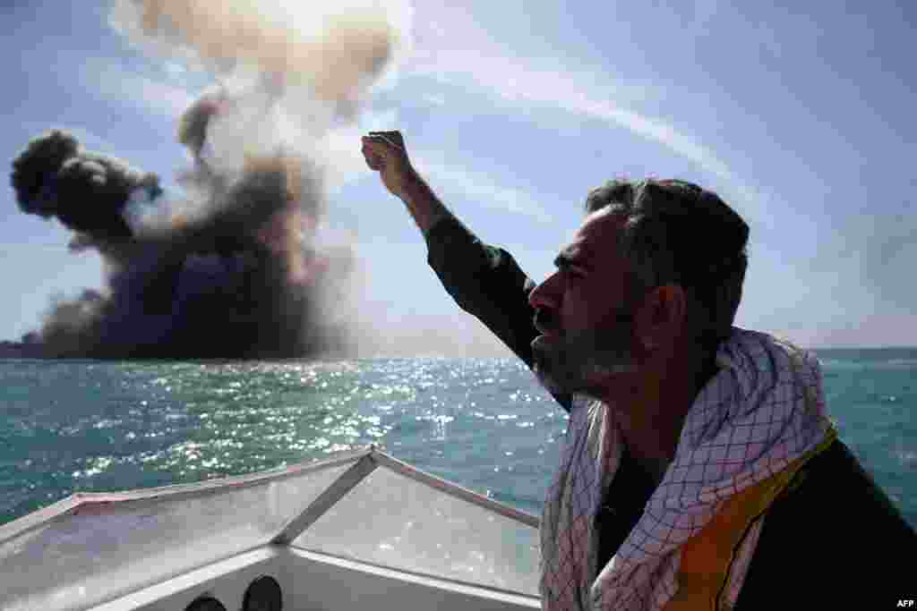 A member of Iran&#39;s elite Revolutionary Guards chants slogans after attacking a naval vessel during a military drill in the Strait of Hormuz in southern Iran on February 25. (AFP/Hamed Jafarnejad)