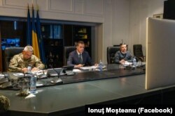 Ministrul român al Apărării, Ionuț Moșteanu (în centru) în timpul videoconferinței pe tema zidului anti-drone, coordonată de comisarul euopean pentru Apărare, Andrius Kubilius.