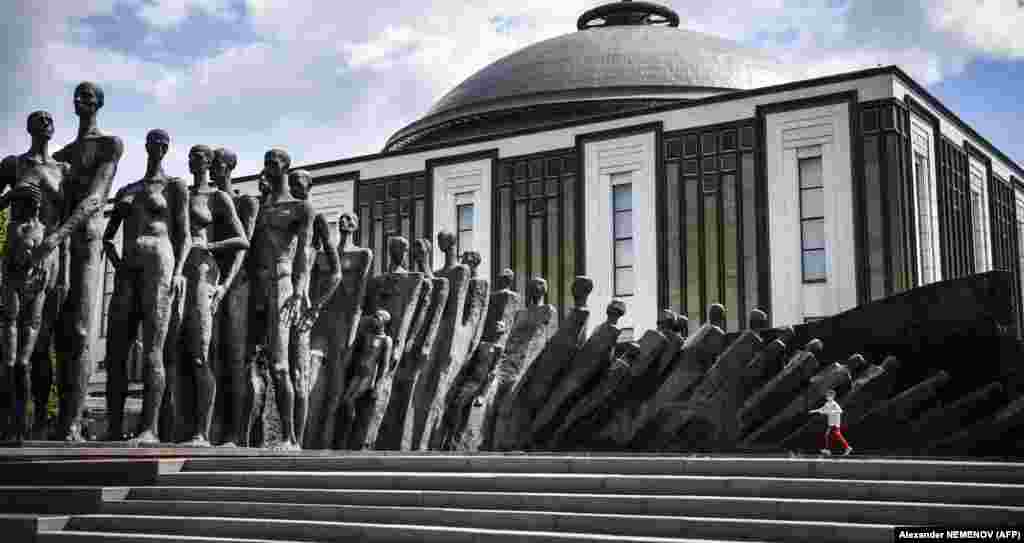 A boy runs past a World War II memorial sculpture titled The Tragedy of the Peoples by Zurab Tsereteli at Poklonnaya Hill in western Moscow. (AFP/Aleksandr Nemenov)