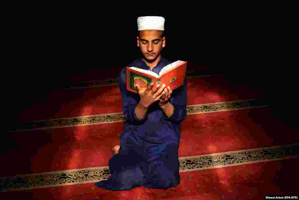 A Pakistani boy reads verses from the Koran at a mosque during the fasting month of Ramadan, amid the coronavirus pandemic, in Peshawar, Pakistan. (epa-EFE/Bilawal Arbab)