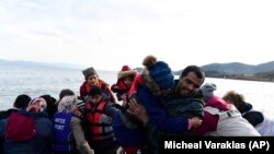 Refugiați și migranți care ajung în satul Skala Sikaminias, de pe insula greacă Lesbos, după ce au traversat marea Egee