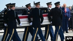 US President Donald Trump salutes as a US Army carry team carries a flag-draped transfer case during an event for US service members killed during operations in the Middle East, in Dover, Delaware, on July 22.