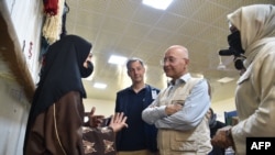 الکساندر دی کرو، رئیس برنامه توسعه‌ای ملل متحد و برهم صالح، کمیشنر عالی ملل متحد در امور پناهندگان در حال صحبت با یک زن افغان در یک کارخانه قالین‌بافی در شهر مزار شریف