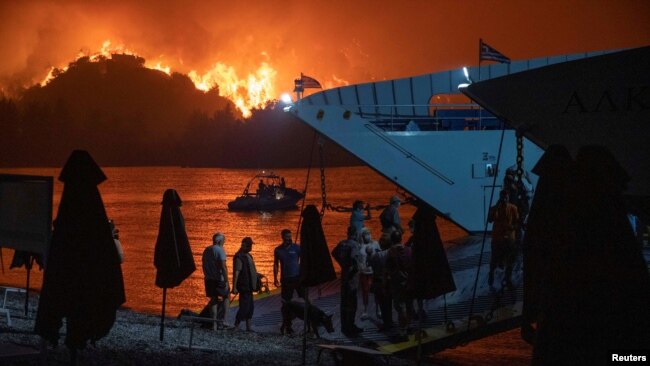 Njerëzit evakuohen përmes një trageti pasi një zjarr i madh përfshiu ishullin Evia, Greqi, 6 gusht 2021.
