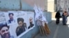 AFGHANISTAN -- Afghan women walk by posters of Taliban leaders and flags in Kabul, August 25, 2021