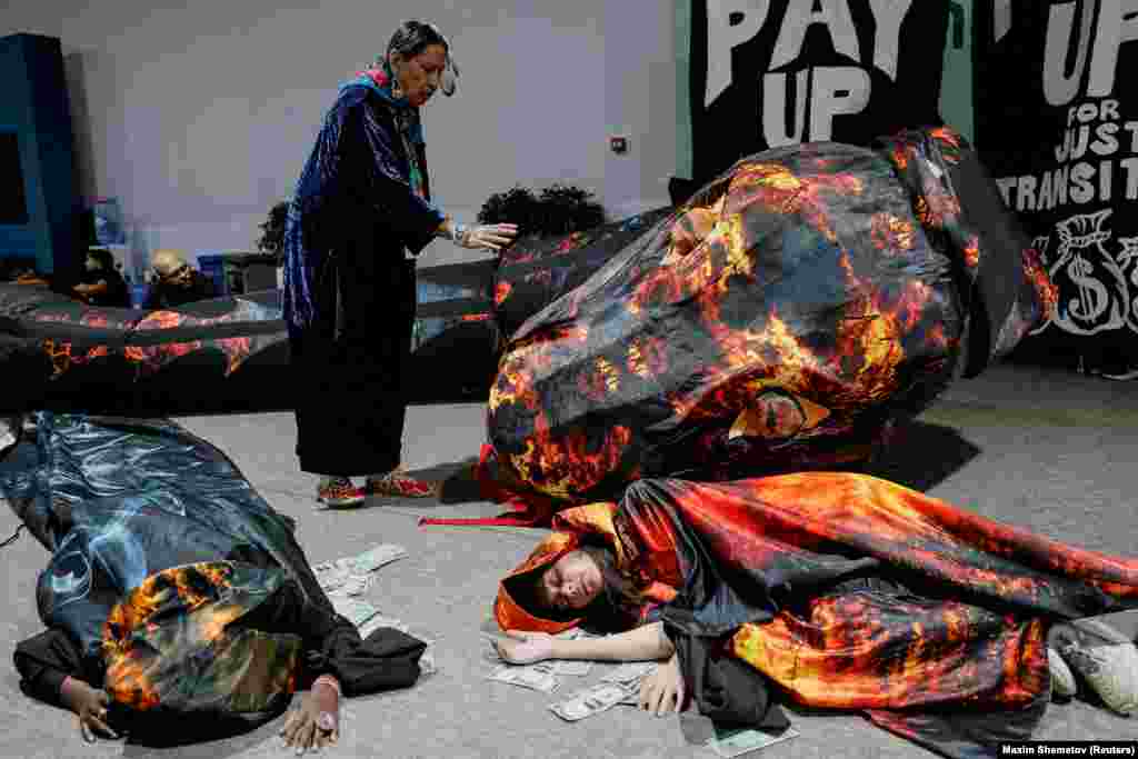 Activists lie next to fake currency bills as they participate in a protest at the COP29 UN climate change conference in Baku, Azerbaijan.