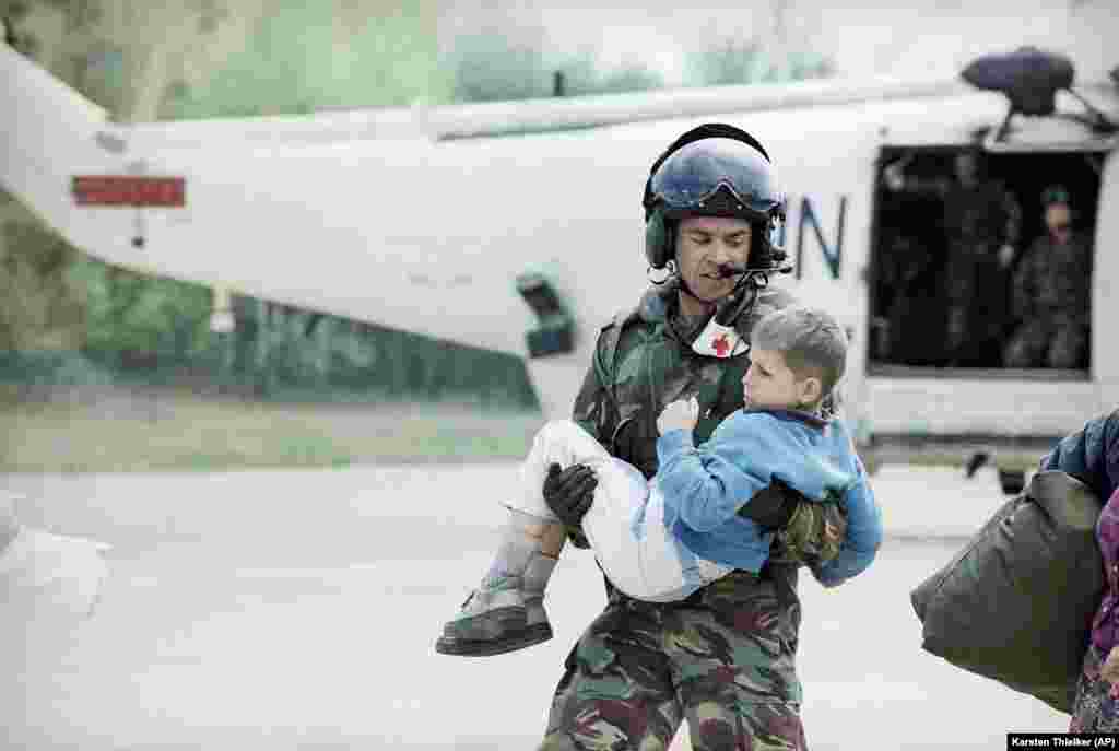 Një pilot francez mban në duar një djalë që është evakuuar nga Srebrenica në Aerportin e Tuzlës më 25 prill, 1993.