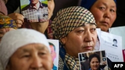 Petitioners with relatives missing or detained in Xinjiang hold up photos of their loved ones in Almaty, Kazakhstan, on January 21.