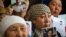 Petitioners with relatives missing or detained in Xinjiang hold up photos of their loved ones in Almaty, Kazakhstan, on January 21.