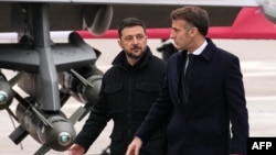 Președintele Franței, Emmanuel Macron (dreapta), și liderul de la Kiev, Volodimir Zelenski, la baza aeriană Villacoublay, de lângă Paris, unde au semnat o declarație de intenții privind livrarea către Ucraina a până la 100 de avioane de luptă franceze „Rafale”, 17 noiembrie 2025.