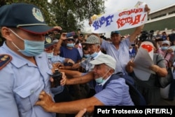 Полицейлер митинг қатысушыларынан плакатын тартып алуға тырысып жатыр. Алматы, 6 шілде 2021 жыл.