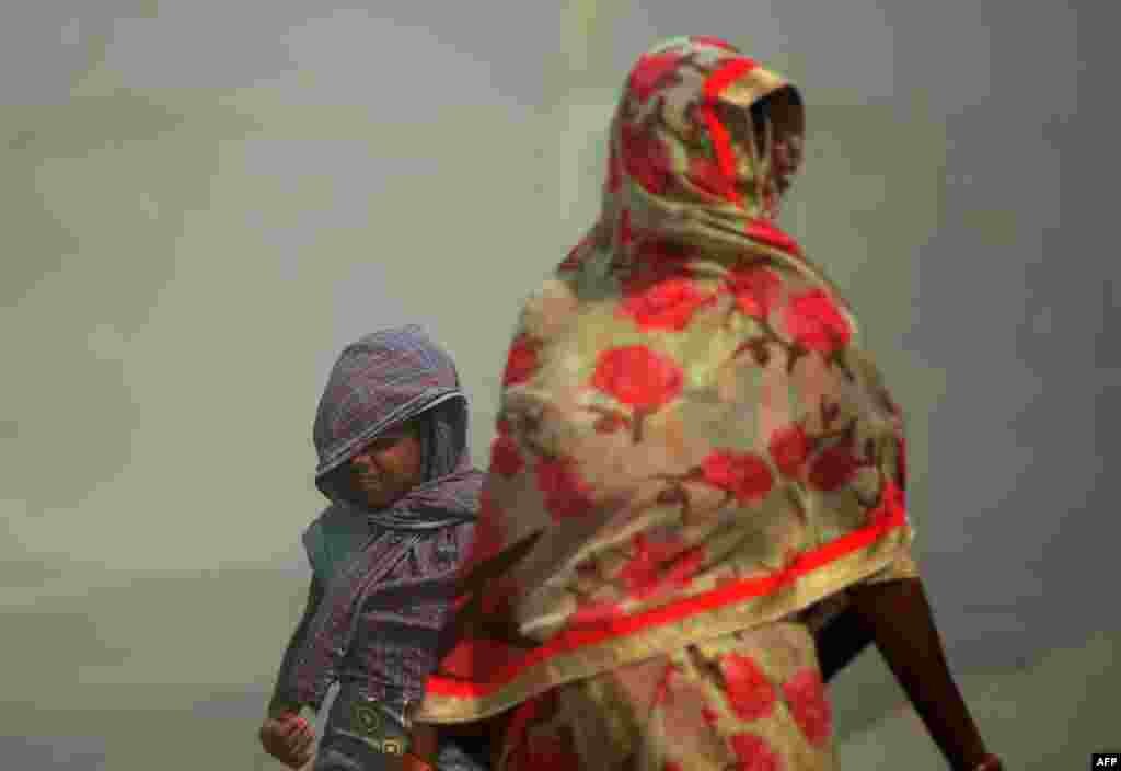 Indian pedestrians walk through a dust storm in Allahabad. (AFP/Sanjay Kanojia)