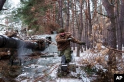 Invalid iz ukrajinske 127. brigade koji je izgubio nogu u borbi 2015. godine skida kamuflažu sa samohodne haubice 10. februara.