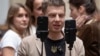 Народний депутат Олексій Гончаренко тримає смартфони, ведучи пряму трансляцію засідання українського парламенту в Києві, Україна, 8 січня 2025 року