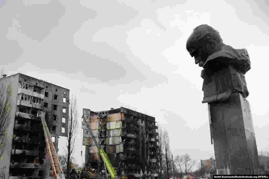 Пам'ятник Тарасу Шевченку у Бородянці, на фоні – зруйновані російськими авіанальотами багатоповерхівки. 8 квітня 2022 року
