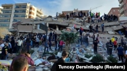 Locals and officials search for survivors at a collapsed building after a strong earthquake struck the Aegean Sea on Friday and was felt in both Greece and Turkey, where some buildings collapsed in the coastal province of Izmir, Turkey, October 30, 2020