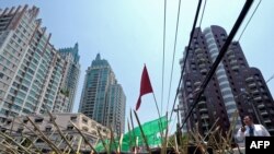 A businessman (right) walks past barricades during an antigovernment protest at the main shopping district of central Bangkok.