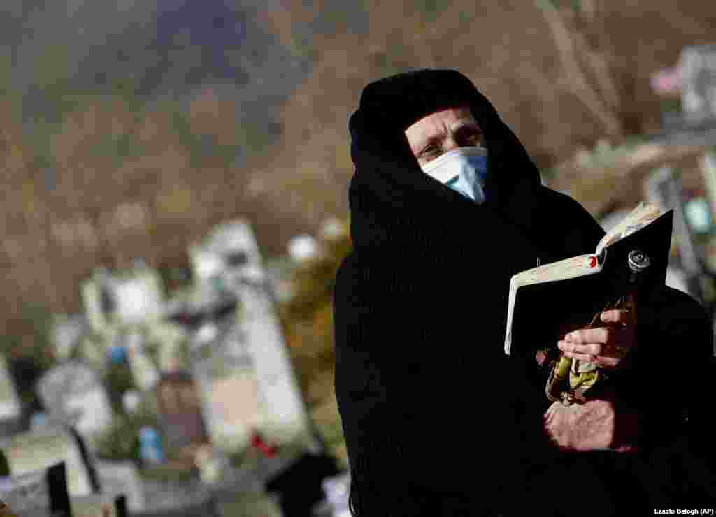 Një hungareze, që ka vendosur maskë për t&rsquo;u mbrojtur nga pandemia, merr pjesë në shërbimet e Kishës Luteriane në Csovari. Shërbimet kjo kishë po i mban në ambient të hapur. (AP/Laszlo Balogh)